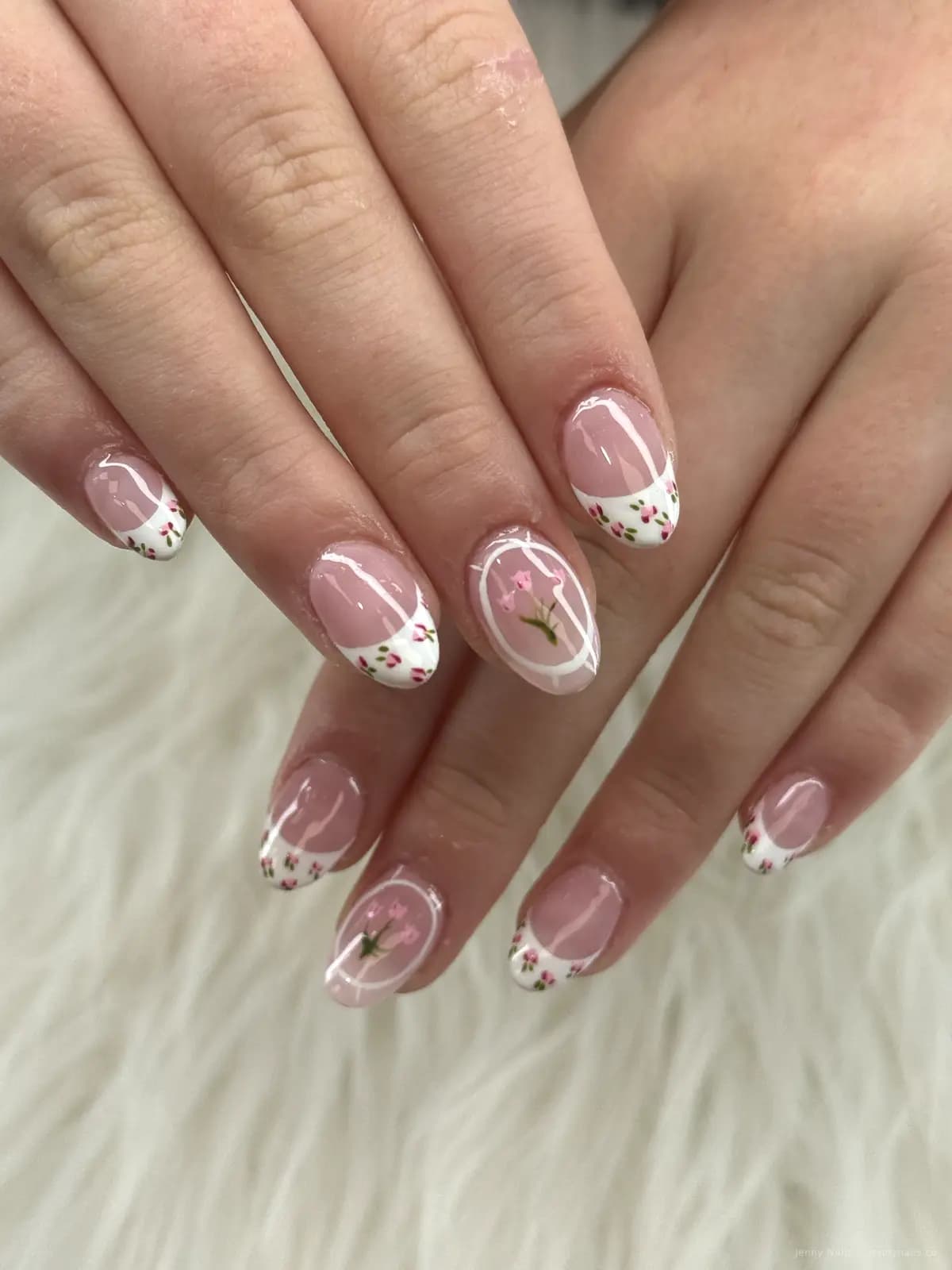 Soft pink nails with white tips and small floral details