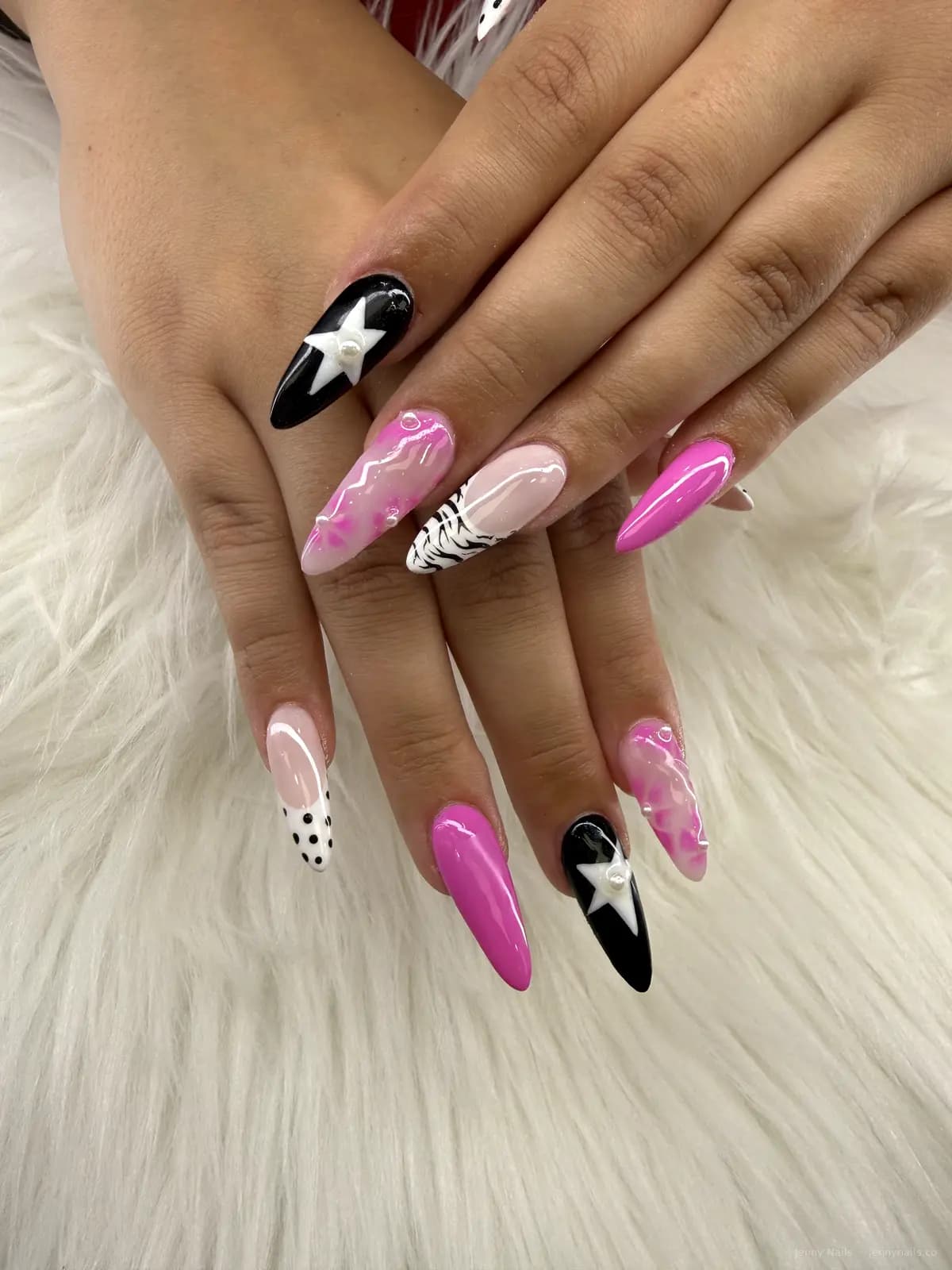 Bright pink, black, and white nails with star accents
