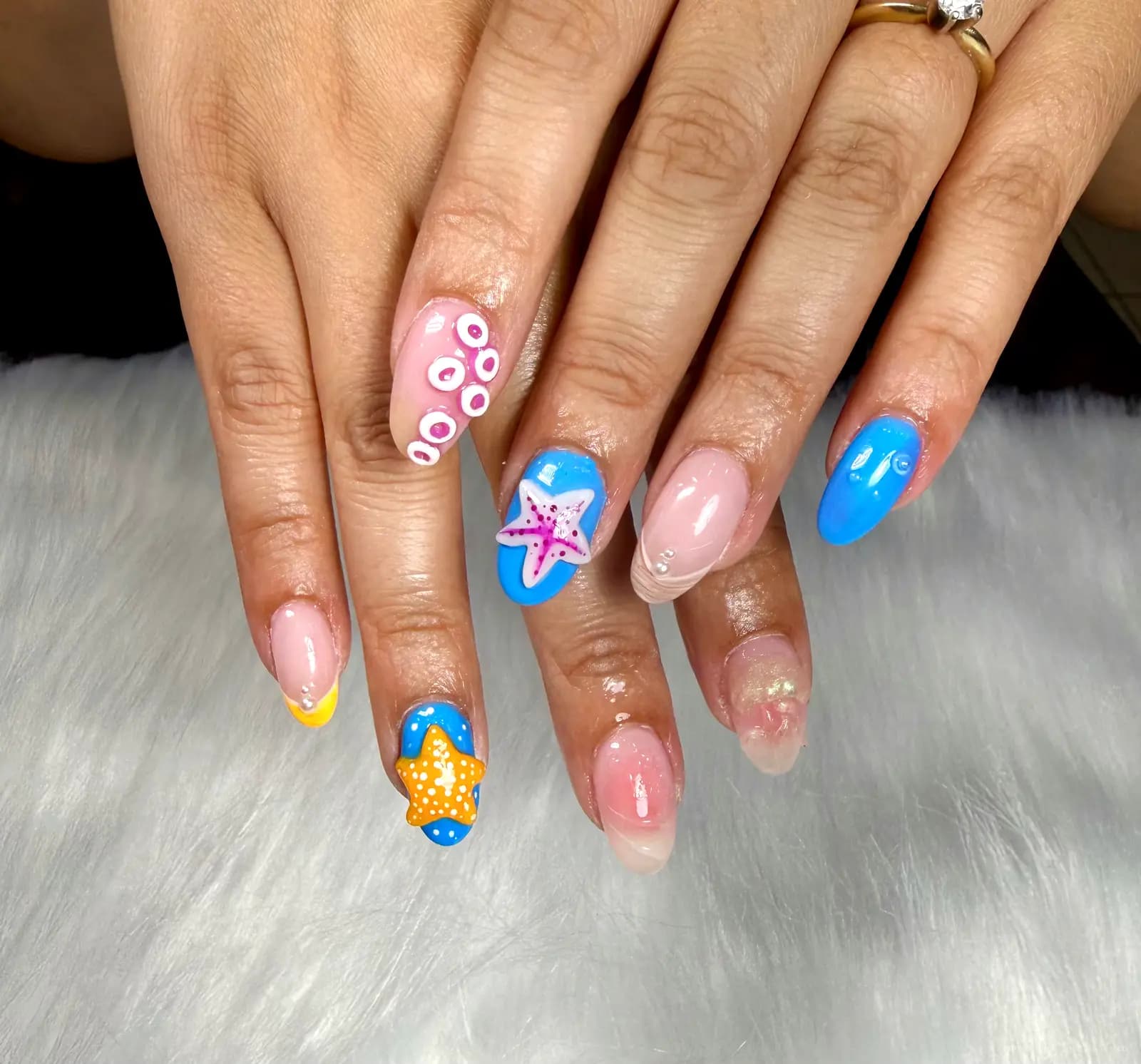Colorful ocean-themed nails with blue accent art
