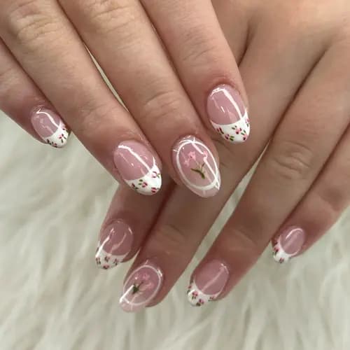 Soft pink nails with white tips and small floral details